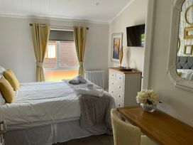 A bedroom with a bed and dresser at White Acres Holiday Park - Holiday Accommodation 22327, Whitecross, Newquay