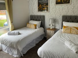 A bedroom with two beds and a side table at White Acres Holiday Park - Holiday Accommodation 22327 Whitecross, Newquay