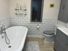 A bathroom featuring a bathtub, toilet, sink, and shelf at White Acres Holiday Park - Holiday Accommodation 22327, Whitecross, Newquay