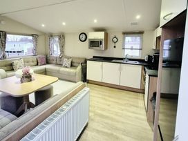 A living room with a sofa and kitchen area at Butlins Minehead - Holiday Accommodation 22343 Minehead