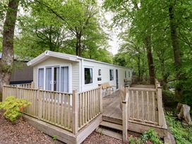 A static caravan with decking and chairs at 145 Woodside View Porthmadog