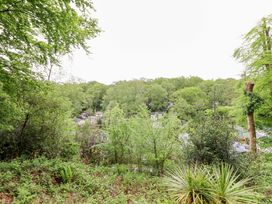 A view of trees and houses at 145 Woodside View in Porthmadog