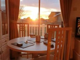 a dining area with a round table and chairs near a window at Coral Beach - Holiday Accommodation 22375 in Ingoldmells