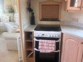 a kitchen area featuring a stove with an oven and a dish towel at Coral Beach - Holiday Accommodation 22375 in Ingoldmells