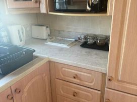 a kitchen countertop with a kettle, toaster, jars, and kitchen appliances at Coral Beach - Holiday Accommodation 22375 in Ingoldmells