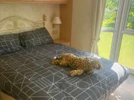 a bedroom with a bed, pillows, and a stuffed animal on the bed at Coral Beach - Holiday Accommodation 22375 In Ingoldmells