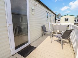 A deck with chairs at Ty Mawr Holiday Park - Holiday Accommodation 22393 Towyn