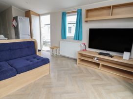 A living room with a sofa and television at Ty Mawr Holiday Park - Holiday Accommodation 22393 Towyn