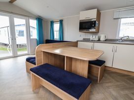 A dining room with a table and benches at Ty Mawr Holiday Park - Holiday Accommodation 22393 Towyn