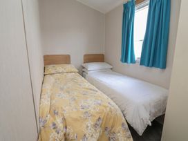 A bedroom with two beds and a window at Ty Mawr Holiday Park - Holiday Accommodation 22393 Towyn
