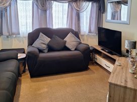 A living room with a sofa, television, and lamp at Southview Holiday Park - Holiday Accommodation 250 Skegness