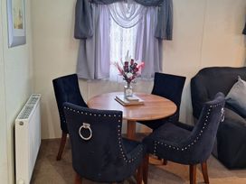 A dining area with a round table and chairs at Southview Holiday Park - Holiday Accommodation 250, Skegness