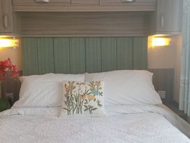 A bedroom with a bed and decorative cushions at Primrose Valley Holiday Park - Holiday Accommodation 2533, Filey
