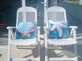 Two adirondack chairs with decorative pillows at Primrose Valley Holiday Park - Holiday Accommodation 2533, Filey