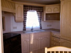 A kitchen with a sink and stove at Coastfield Holiday Village - Holiday Accommodation 2604 in Ingoldmells