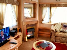 A living room with a television and fireplace at Coastfield Holiday Village - Holiday Accommodation 2604 in Ingoldmells