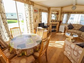 A living room with a table and chairs at Coastfield Holiday Village - Holiday Accommodation 2604 in Ingoldmells