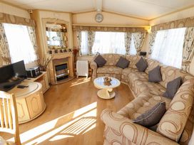 A living room with a sofa and television at Coastfield Holiday Village - Holiday Accommodation 2604 Ingoldmells