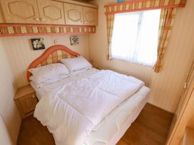 A bedroom with a bed and furniture at Coastfield Holiday Village - Holiday Accommodation 2604 in Ingoldmells