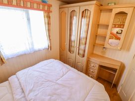 A bedroom with a bed and wardrobe at Coastfield Holiday Village - Holiday Accommodation 2604 Ingoldmells
