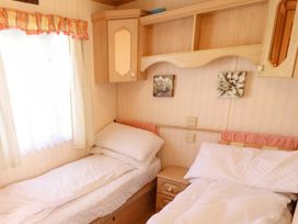 A bedroom with two single beds and a dresser at Coastfield Holiday Village - Holiday Accommodation 2604 in Ingoldmells