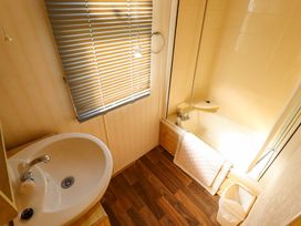A bathroom featuring a sink and a bath tub at Coastfield Holiday Village - Holiday Accommodation 2604 in Ingoldmells