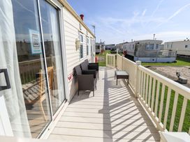 A deck with table and chairs at Coastfield Holiday Village - Holiday Accommodation 2604 Ingoldmells