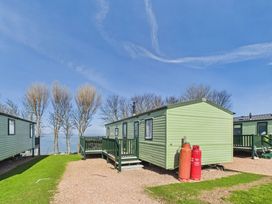 A green caravan near trees at St Andrews Holiday Park - Holiday Accommodation 2944, St Andrews