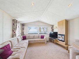 A living room with a sectional sofa and television at St Andrews Holiday Park - Holiday Accommodation 2944 in St Andrews