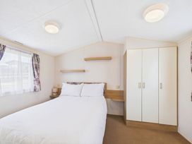A bedroom with a bed and wardrobe at St Andrews Holiday Park - Holiday Accommodation 2944, St Andrews