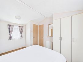 A bedroom with a bed, wardrobe, and mirror at St Andrews Holiday Park - Holiday Accommodation 2944, St Andrews