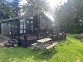 An outdoor area with a wooden cabin and picnic table at Haggerston Castle - Holiday Accommodation 3441 Berwick-upon-Tweed