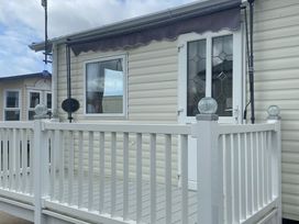 A doorway and windows on a deck at Happy Days Caravan Park - Holiday Accommodation 3599 Towyn