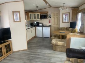 A kitchen with appliances and seating at Happy Days Caravan Park - Holiday Accommodation 3599 Towyn