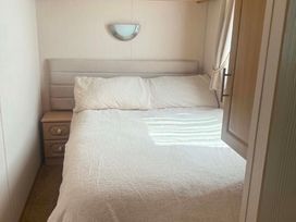 A bedroom featuring a bed and a bedside table at Happy Days Caravan Park - Holiday Accommodation 3599, Towyn