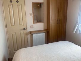 A bedroom with a mirror and wardrobe at Happy Days Caravan Park - Holiday Accommodation 3599, Towyn