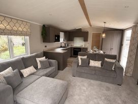 A living room with sofas and kitchen units at Berwick Holiday Park - Holiday Accommodation 37, Berwick-upon-Tweed