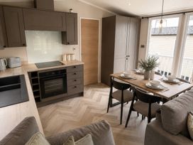 A kitchen and dining area with table and chairs at Berwick Holiday Park - Holiday Accommodation 37 Berwick-upon-Tweed