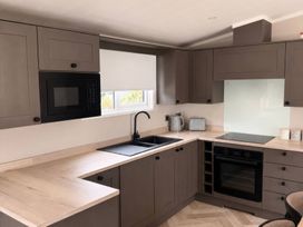 A kitchen with a sink, microwave, and oven at Berwick Holiday Park - Holiday Accommodation 37, Berwick-upon-Tweed