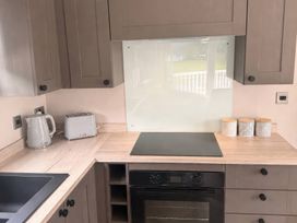 A kitchen with a kettle, toaster, and cooktop at Berwick Holiday Park - Holiday Accommodation 37, Berwick-upon-Tweed