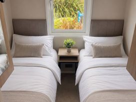 A bedroom with two beds and a bedside table at Berwick Holiday Park - Holiday Accommodation 37 Berwick-upon-Tweed