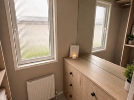 A bedroom with a dresser and window at Berwick Holiday Park - Holiday Accommodation 37, Berwick-upon-Tweed