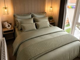 A bedroom with a bed and nightstand at Berwick Holiday Park - Holiday Accommodation 37 Berwick-upon-Tweed
