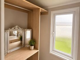 A bedroom corner with a mirror and plant at Berwick Holiday Park - Holiday Accommodation 37, Berwick-upon-Tweed