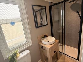 A bathroom with a sink, toilet, shower, and window at Berwick Holiday Park - Holiday Accommodation 37 Berwick-upon-Tweed