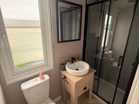 A bathroom with a toilet, sink, and shower at Berwick Holiday Park - Holiday Accommodation 37 in Berwick-upon-Tweed