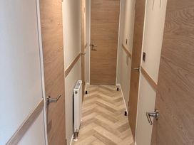 A hallway with multiple doors and a radiator at Berwick Holiday Park - Holiday Accommodation 37 Berwick-upon-Tweed