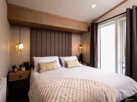 A bedroom with a bed and nightstand at Perran Sands - Holiday Accommodation 4301 Perranporth