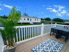 A deck with a table and chairs at 62 Snowdonia View, Hafan y Mor Haven - 4345, Pwllheli