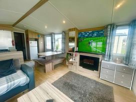 A living room featuring a TV, dining table, and sofa at 62 Snowdonia View, Hafan y Mor Haven - 4345 Pwllheli